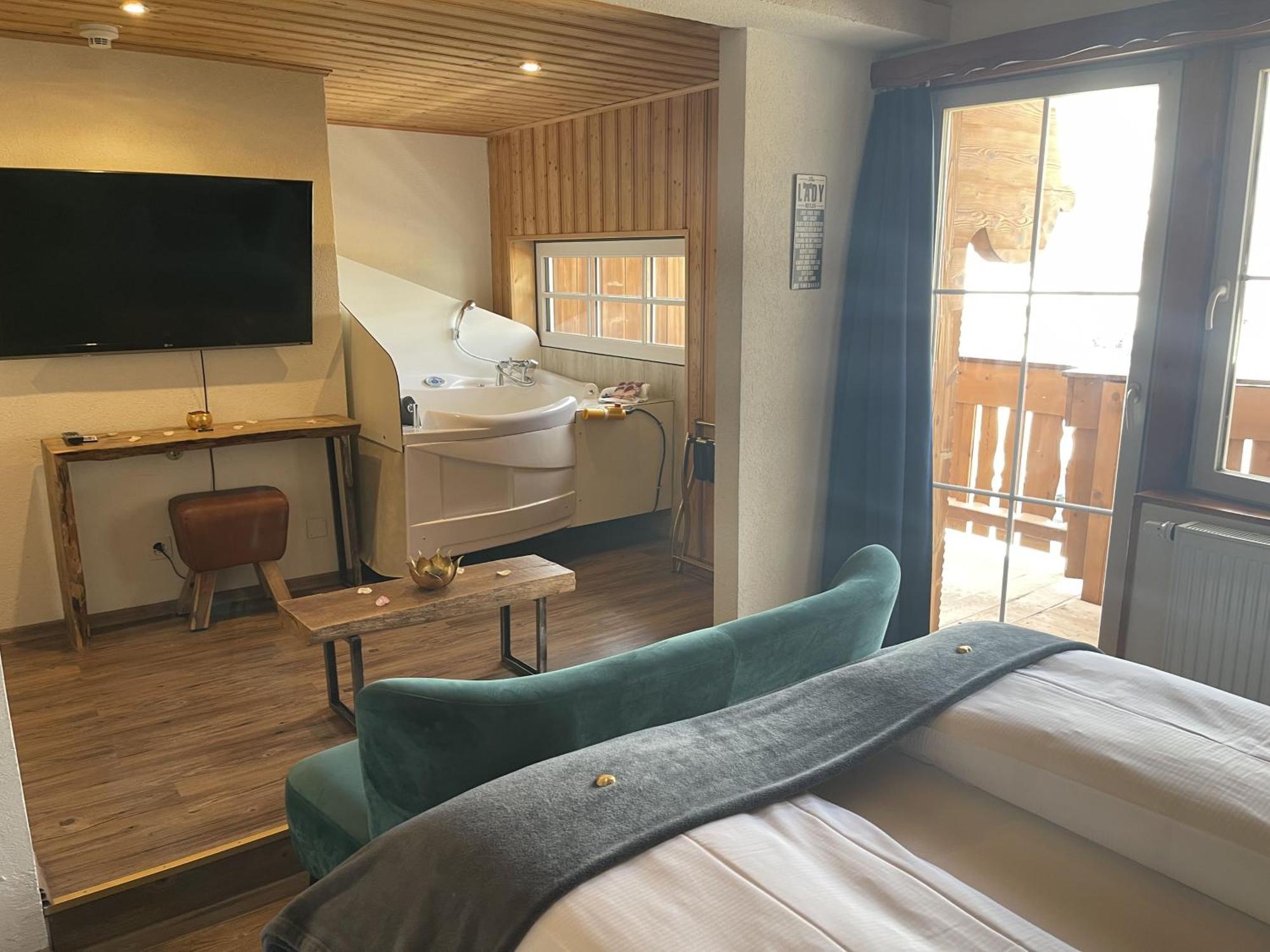 Zimmer mit Queensize-Bett und Whirlpool-Badewanne